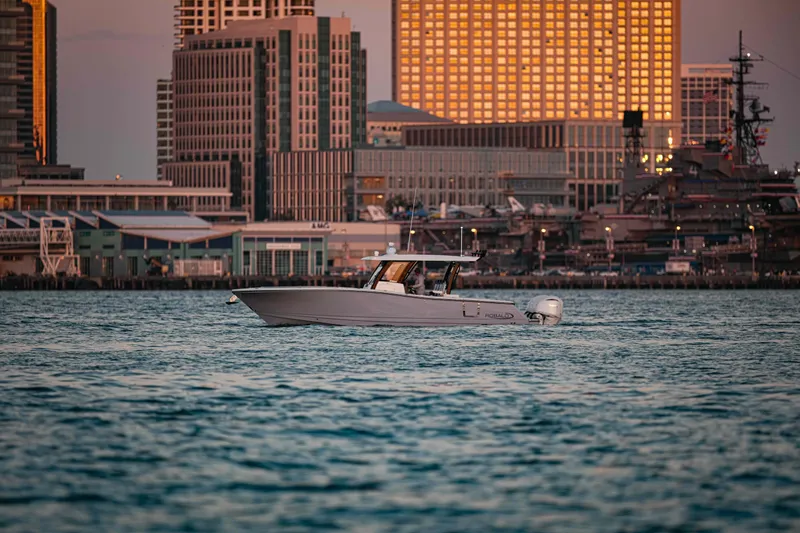 The Image of 2024 Robalo R360 Center Console boat cruising at sunset on the water. - 0