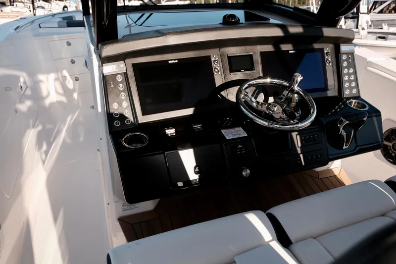 Slide: The Image of 2024 Robalo R360 Center Console boat dashboard with modern controls and steering wheel. - 14