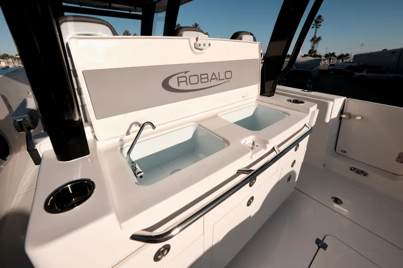 Slide: The Image of 2024 Robalo R360 Center Console boat with dual sinks and storage compartments. - 16
