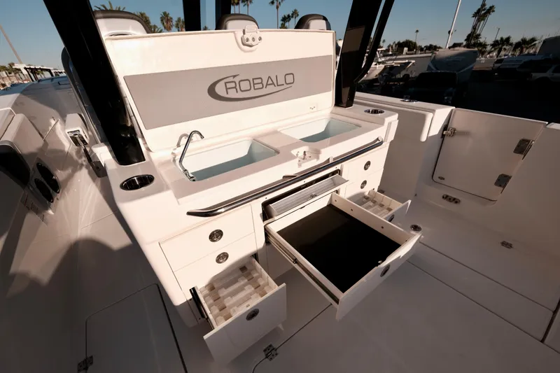 Slide: The Image of 2024 Robalo R360 Center Console boat interior with storage compartments and sink. - 17