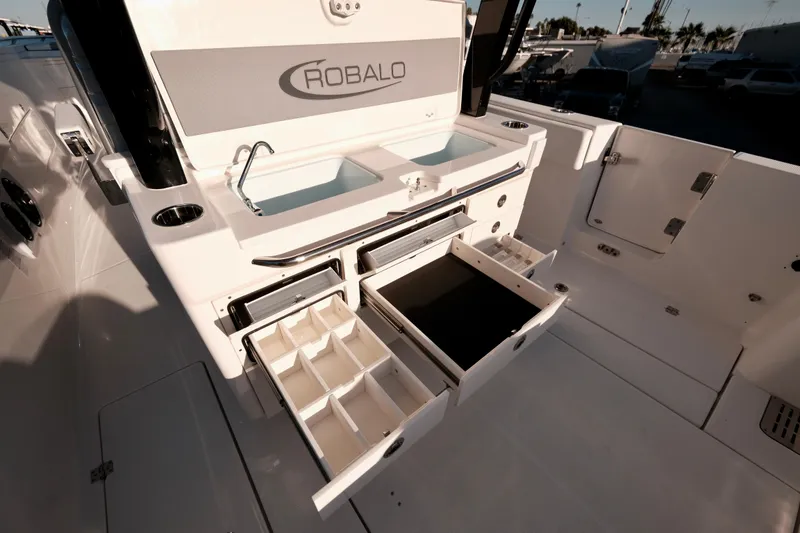 Slide: The Image of 2024 Robalo R360 Center Console boat with open storage compartments and sink. - 18