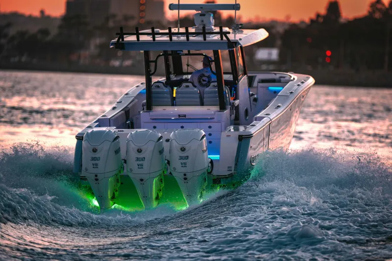 Slide: The Image of 2024 Robalo R360 Center Console boat on urban waterfront at sunset. - 2