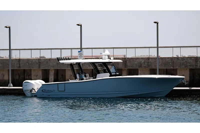 Slide: The Image of 2024 Robalo R360 Center Console boat cruising at sunset with illuminated engines. - 3