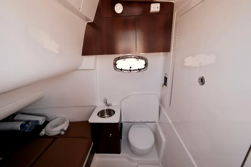 Slide: The Image of 2024 Robalo R360 Center Console boat interior with sink, toilet, and storage. - 34