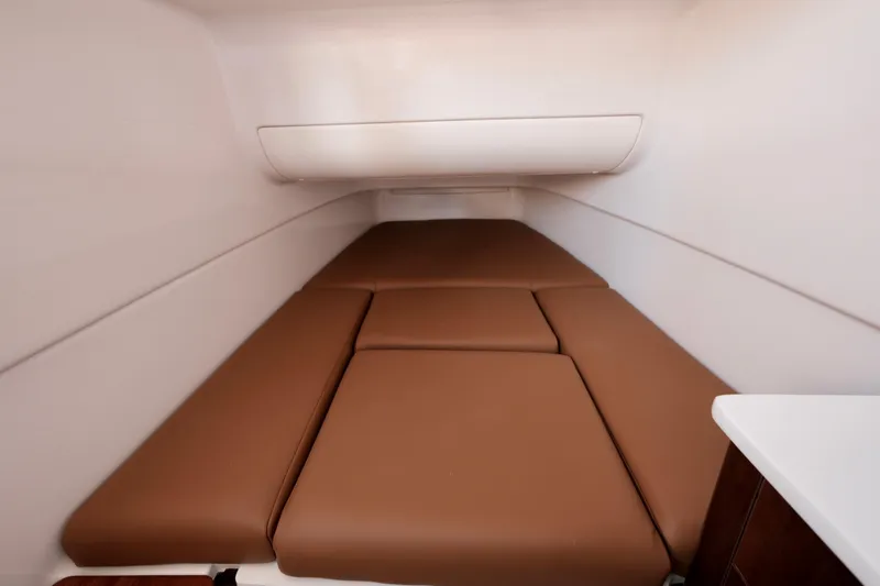 Slide: The Image of 2024 Robalo R360 Center Console cabin interior with brown cushioned seating. - 35