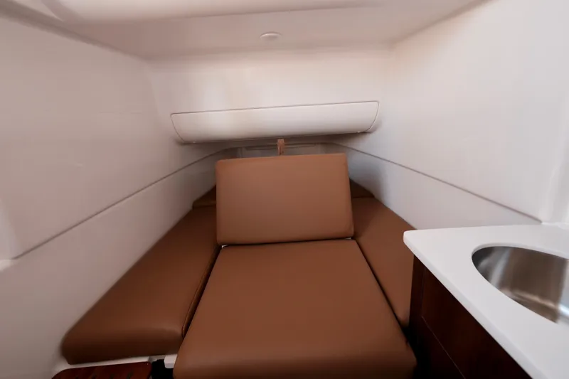 Slide: The Image of 2024 Robalo R360 Center Console cabin interior with brown seating and sink. - 36