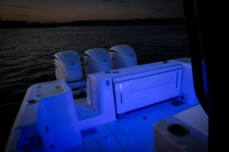 Slide: The Image of 2024 Robalo R360 Center Console boat with illuminated deck at dusk. - 50