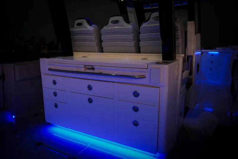 Slide: The Image of 2024 Robalo R360 Center Console with illuminated seating and storage, featuring blue LED lighting. - 51