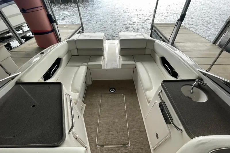 Slide: The Image of 2008 Regal 2700 Bowrider interior with seating and sink, docked by the water. - 3