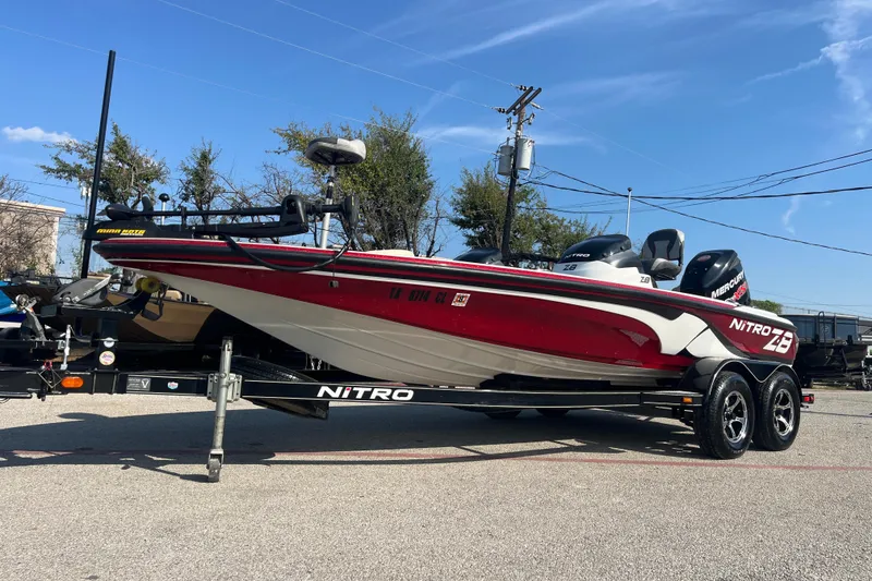 Slide: The Image of Red Nitro Z-8 boat, 2015 model, 250HP PROxs engine, 59 hours, parked by a lake. - 0