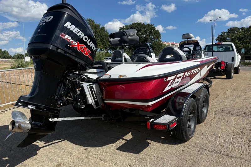 Slide: The Image of 2015 Nitro Z-8 boat on trailer by a lake under a cloudy sky. - 52