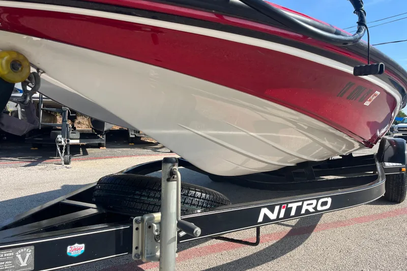 Slide: The Image of 2015 Nitro Z-8 boat on trailer, red and white design, parked outdoors. - 6