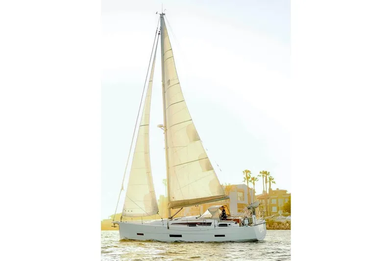 The Image of 2020 Dufour 430 sailboat with couple on deck, sailing on calm waters. - 0