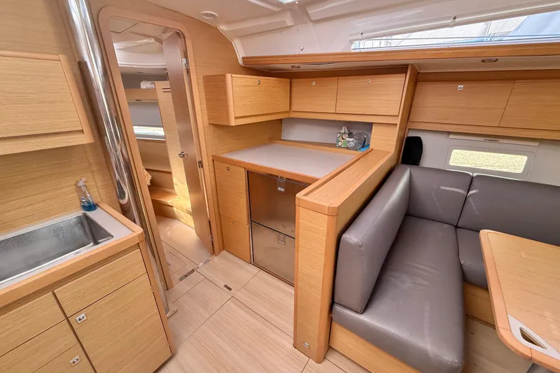 Slide: The Image of 2020 Dufour 430 yacht interior with modern wood finish and spacious seating area. - 18