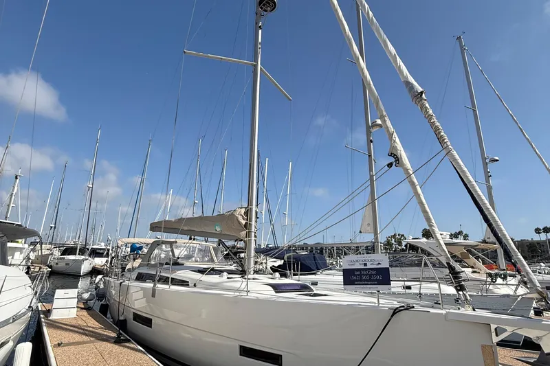 Slide: The Image of 2020 Dufour 430 sailboat with people relaxing on deck, sailing on calm waters. - 4