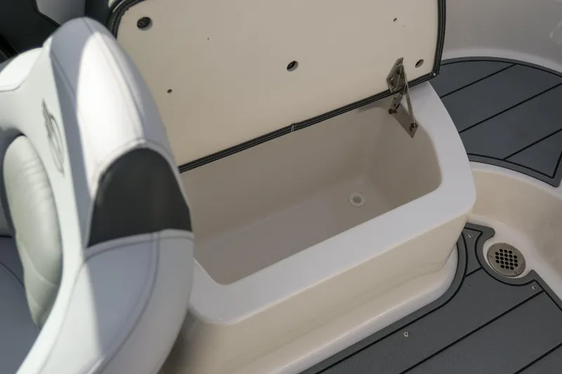Slide: The Image of Open storage compartment on 2025 Chaparral 247 SSX boat, featuring sleek seating and flooring. - 21