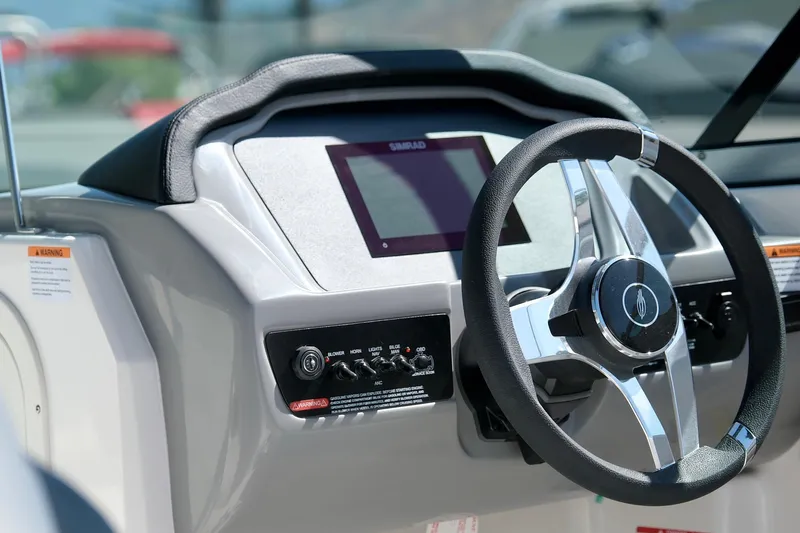Slide: The Image of 2025 Chaparral 23 SSi boat dashboard with steering wheel and control panel. - 13