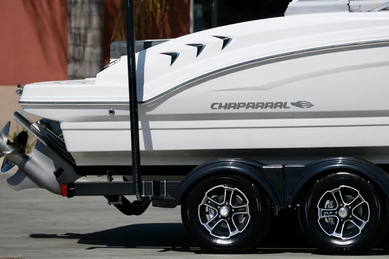 Slide: The Image of 2025 Chaparral 23 SSi boat on trailer, showcasing sleek design and dual propellers. - 3