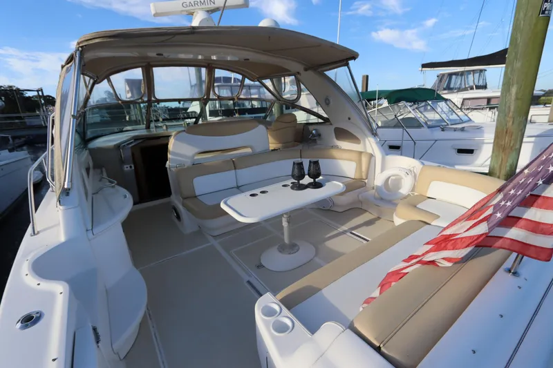 Slide: The Image of 2000 Sea Ray 460 Sundancer yacht interior with seating, table, and American flag. - 10