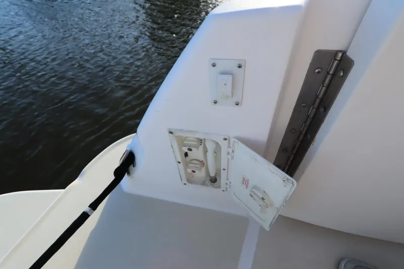 Slide: The Image of 2000 Sea Ray 460 Sundancer boat deck with open utility panel by water. - 14
