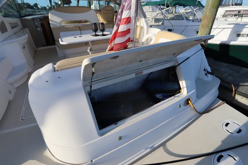 Slide: The Image of 2000 Sea Ray 460 Sundancer yacht with open storage compartment and American flag. - 15