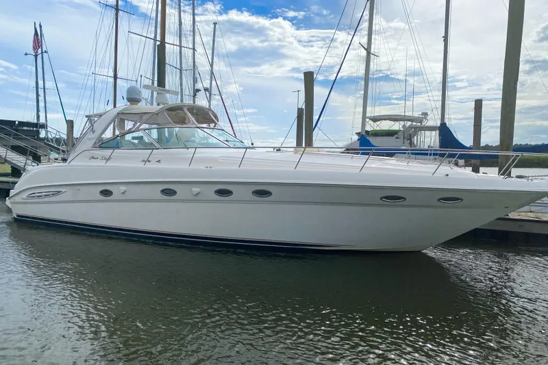 Slide: The Image of 2000 Sea Ray 460 Sundancer yacht docked at marina under blue sky. - 2