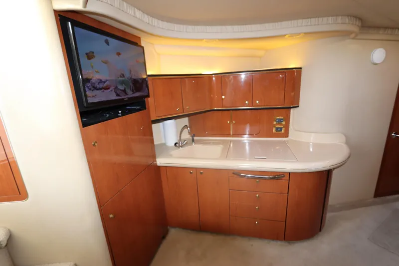 Slide: The Image of Luxurious interior of 2000 Sea Ray 460 Sundancer yacht with modern kitchenette and TV. - 31