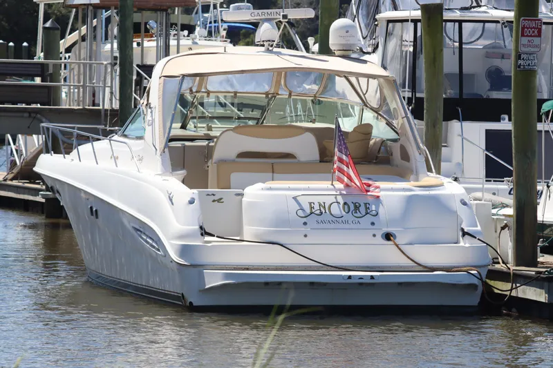 Slide: The Image of 2000 Sea Ray 460 Sundancer yacht docked, featuring "Encore" name and American flag. - 4