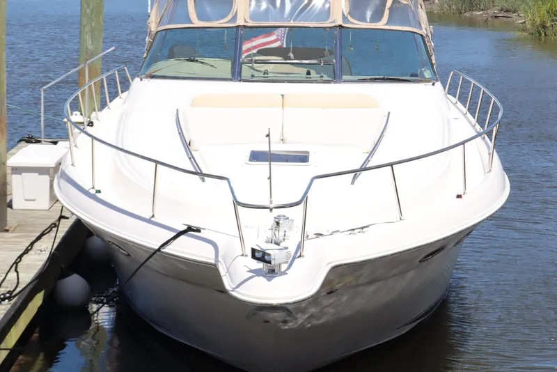 Slide: The Image of 2000 Sea Ray 460 Sundancer yacht docked on calm water, front view. - 5