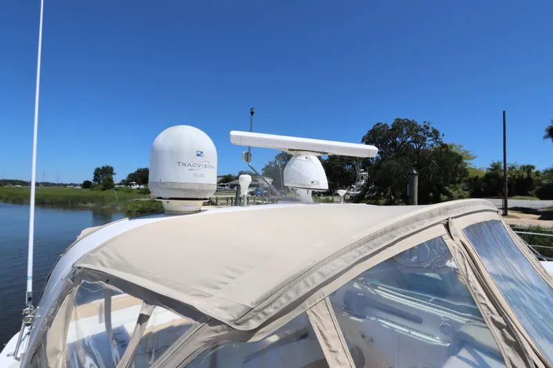 Slide: The Image of 2000 Sea Ray 460 Sundancer yacht with radar and satellite equipment, docked under clear blue sky. - 6