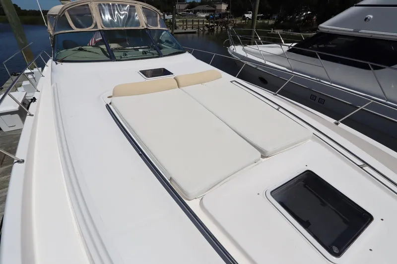 Slide: The Image of 2000 Sea Ray 460 Sundancer yacht with sunbathing deck, docked beside another boat. - 8