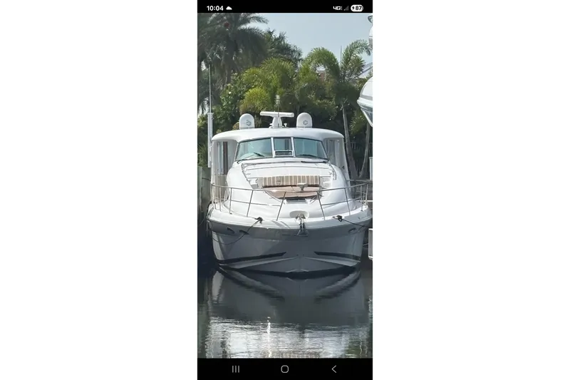 Slide: The Image of 2004 Sea Ray 480 Motor Yacht docked, surrounded by lush greenery. - 0