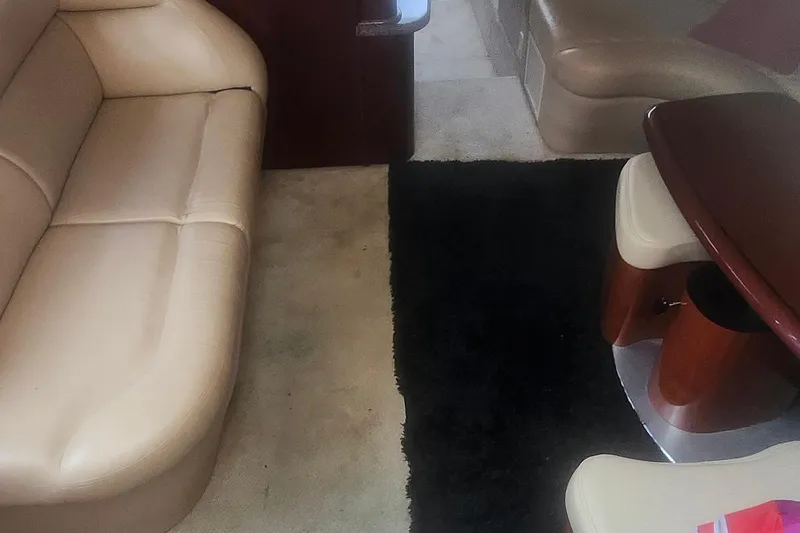 Slide: The Image of Interior of 2004 Sea Ray 480 Motor Yacht with beige seating and dark rug. - 12