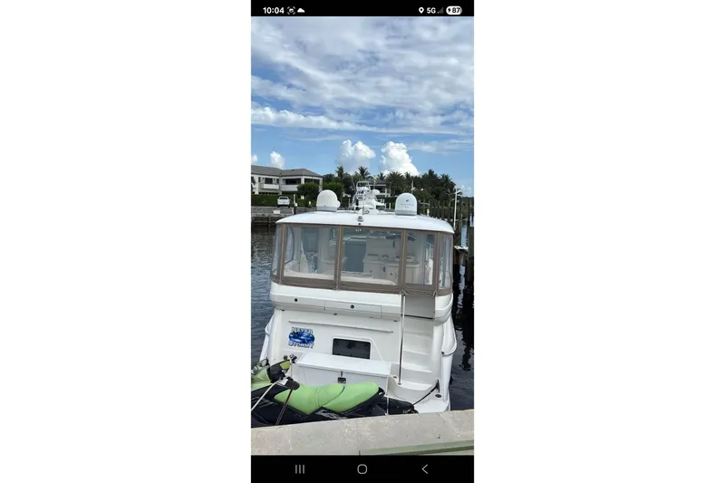 Slide: The Image of 2004 Sea Ray 480 Motor Yacht docked at marina under a partly cloudy sky. - 2