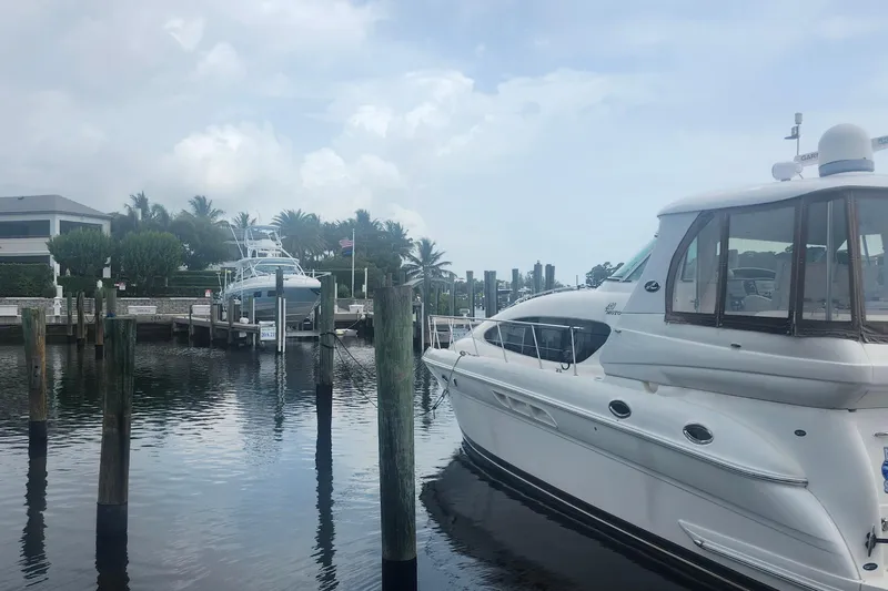 Slide: The Image of 2004 Sea Ray 480 Motor Yacht docked at a marina with palm trees in the background. - 6