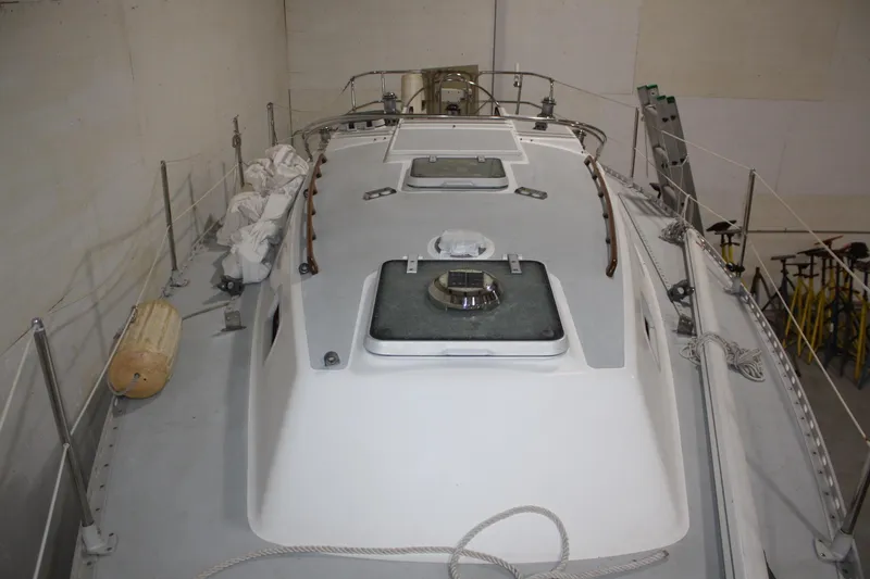 Slide: The Image of 1986 J Boats J/28 sailboat deck view in storage, showcasing hatches and rigging. - 12