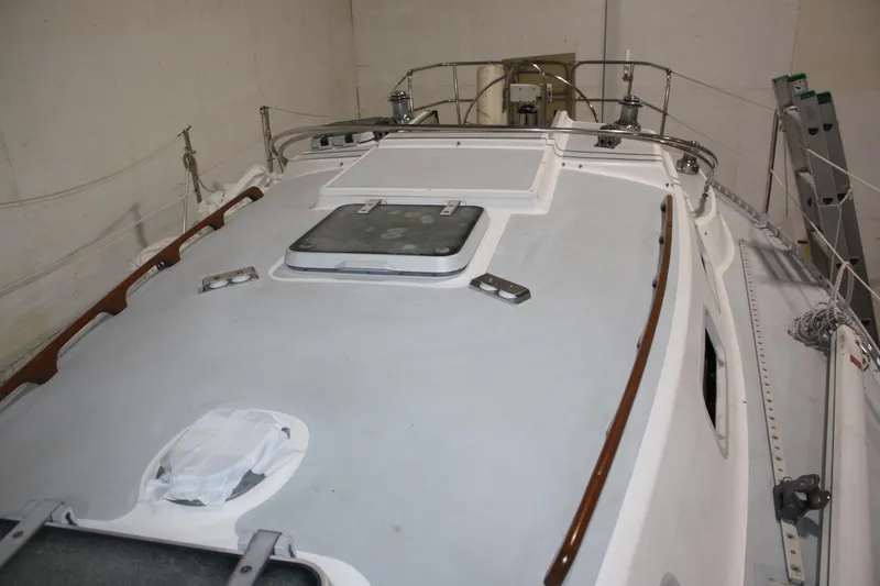 Slide: The Image of 1986 J Boats J/28 sailboat deck view in storage, showcasing hatches and railings. - 14