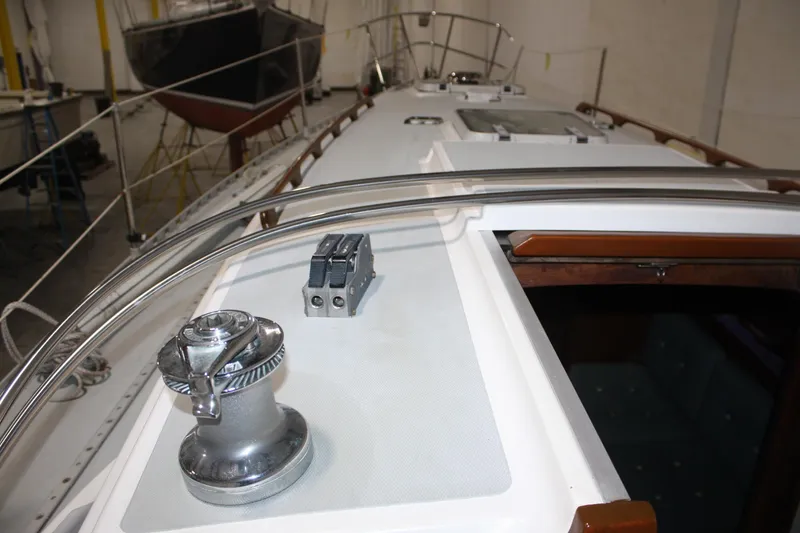 Slide: The Image of 1986 J Boats J/28 sailboat deck with winch and railing in a workshop. - 17