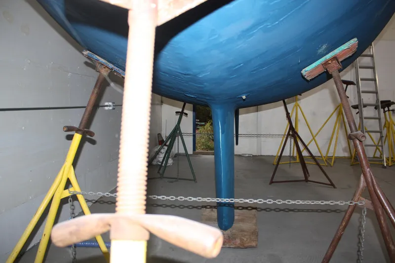 Slide: The Image of 1986 J Boats J/28 sailboat hull supported by stands in a storage area. - 23