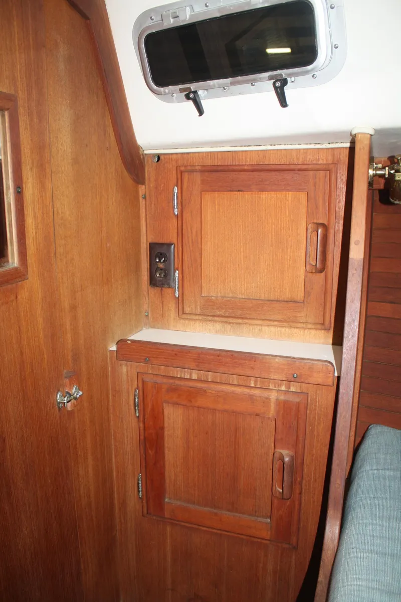 Slide: The Image of 1986 J Boats J/28 interior with wooden cabinets and a small window. - 26