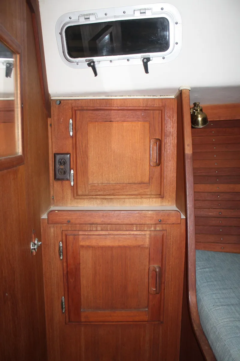 Slide: The Image of 1986 J Boats J/28 interior with wooden cabinets and a small window. - 27