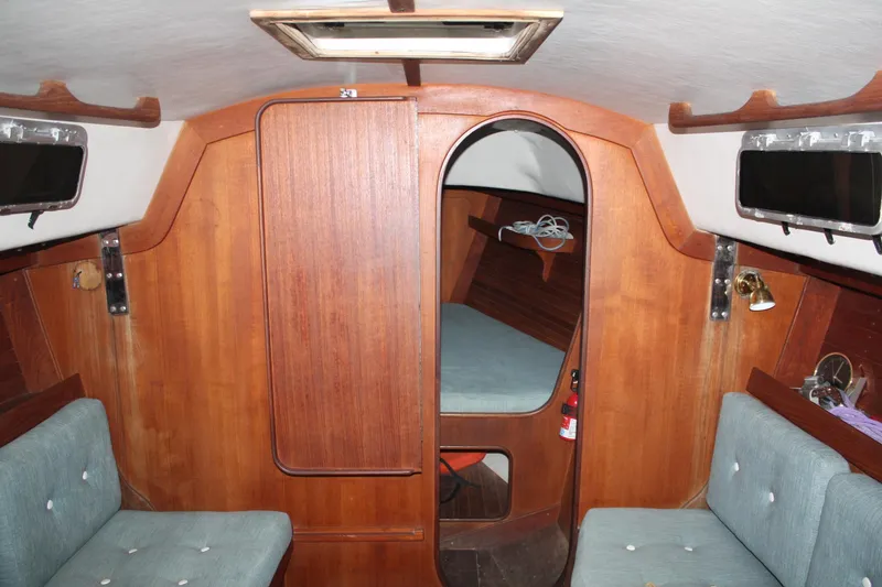 Slide: The Image of Interior of 1986 J Boats J/28 sailboat with wooden paneling and cushioned seating. - 29