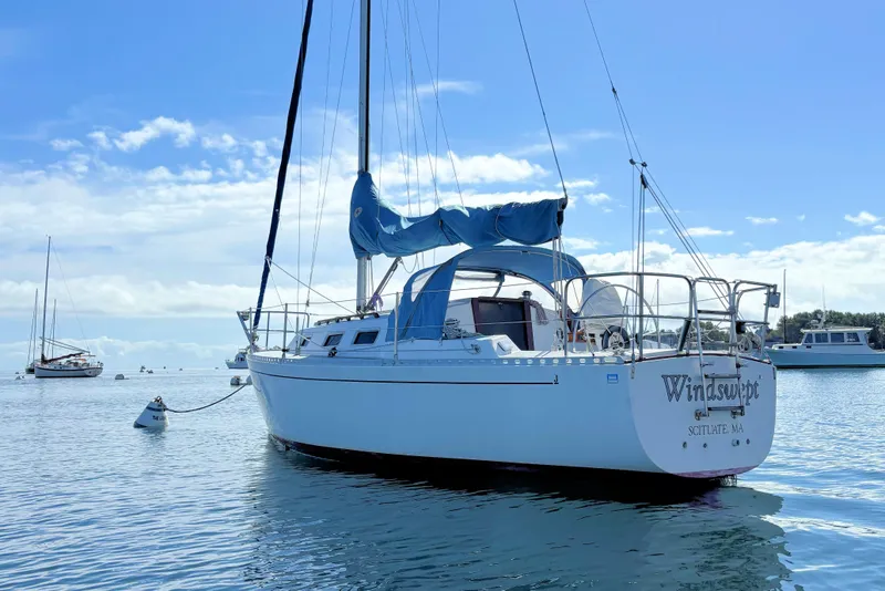 Slide: The Image of 1986 J Boats J/28 sailboat "Windswept" moored on calm water under blue sky. - 3