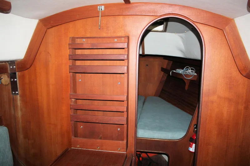 Slide: The Image of Interior of 1986 J Boats J/28 sailboat with wooden paneling and cozy cabin space. - 30