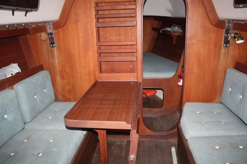 Slide: The Image of 1986 J Boats J/28 interior with wooden table and cushioned seating. - 31