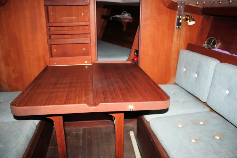 Slide: The Image of Interior of 1986 J Boats J/28 sailboat with wooden table and cushioned seating. - 32