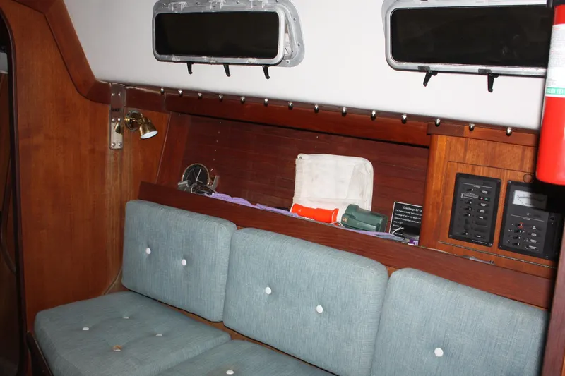Slide: The Image of Interior of 1986 J Boats J/28 sailboat with cushioned seating and wooden paneling. - 37