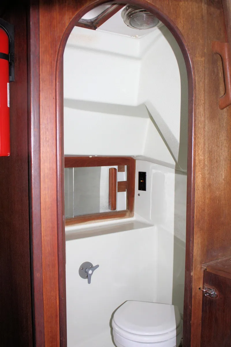 Slide: The Image of 1986 J Boats J/28 sailboat interior bathroom with wooden trim and compact design. - 39