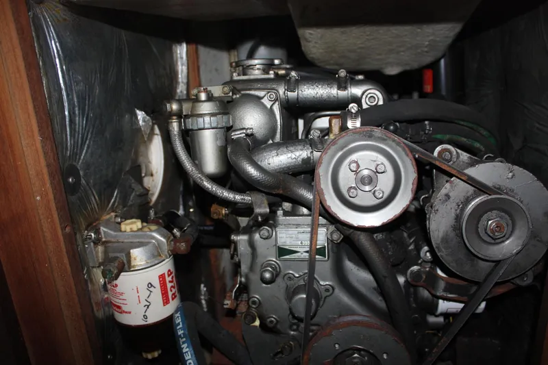 Slide: The Image of Engine compartment of a 1986 J Boats J/28 sailboat, showcasing mechanical components and belts. - 42