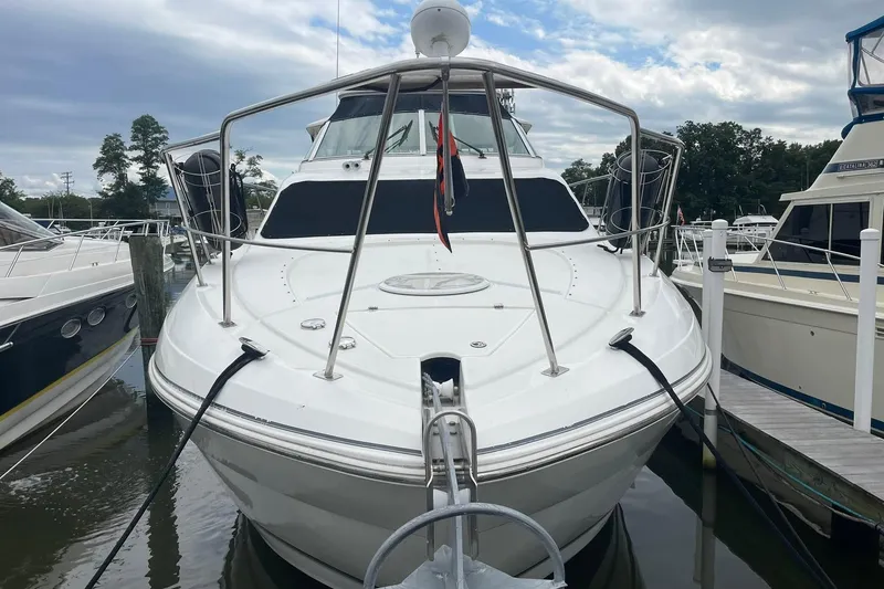 Slide: The Image of 2005 Cruisers Yachts 405 Express Motoryacht docked at marina under clear sky. - 2